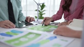 Business colleagues planning a sustainable project with wind turbine models and eco-friendly data sheets - Powered by Shutterstock - Get 15% off with code: PIKWIZARD15