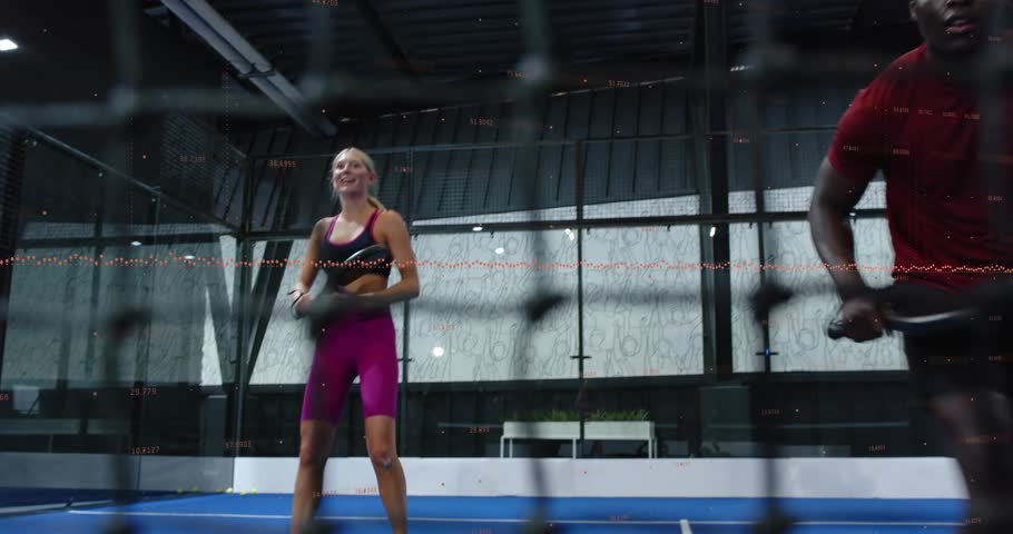 Female athlete swinging paddle initiating padel rally while partner entering court during training. Sports, fitness, outdoor, active, teamwork, competition, modern