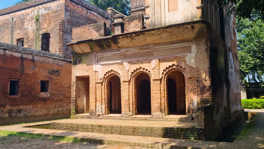An old brick colonial mansion stands in sunlight amid the abandoned ghost town of Panam Nagar in Sonargaon, Bangladesh, echoing the forgotten grandeur of a bygone era