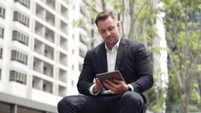 Close up of business people working on tablet while sitting at green city. Low angle camera of manager using his tablet to browsing and searching financial data analysis while remote working. Urbane. - Powered by Shutterstock - Get 15% off with code: PIKWIZARD15