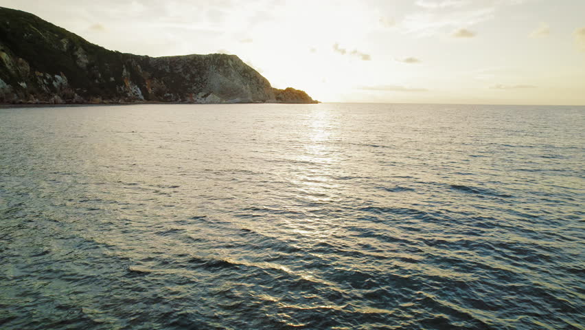 Golden hour sunset over a rocky coastline on Kefalonia island in Greece during summer