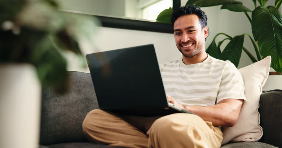 Break, laptop and typing with man on sofa in living room of home for college or university assignment. Computer, relax and report with person in apartment for education, learning or online study