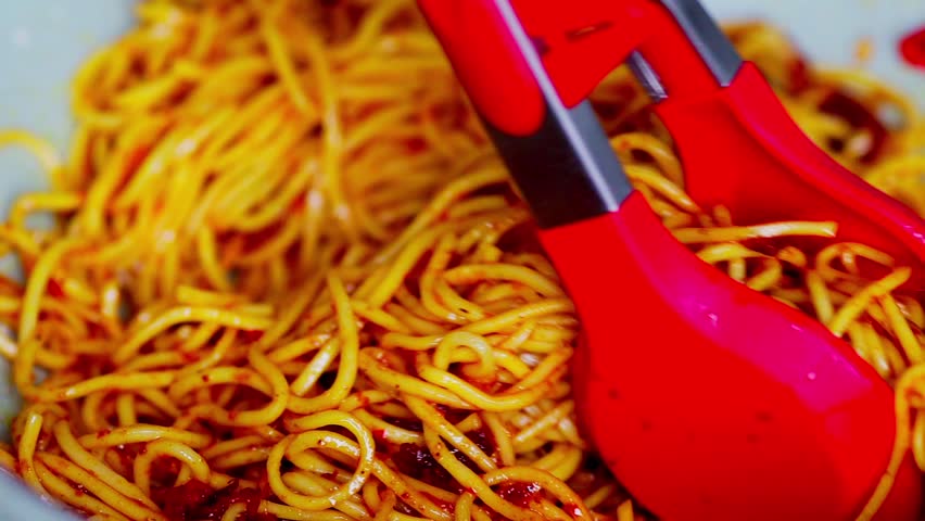 Spicy homemade fried noodles cooking in a pan, with vibrant ingredients sizzling, showing delicious home-cooked meal preparation.