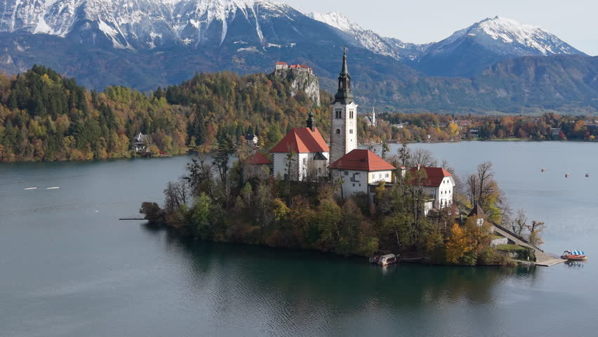 Picturesque view of Bled Island and castle with the Julian Alps in the background during autumn