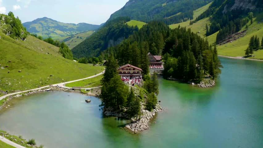 Scenic mountain lake with charming house in summer landscape