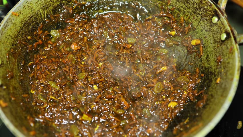 Indian sweet ginger halwa cooking in pan with nuts and ghee