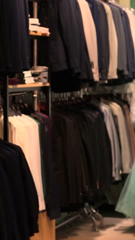 Store preparing for prom and wedding season with affordable colorful dresses and suits for bridesmaids and guests, displayed on racks, offering stylish festive outfits without branded labels.