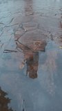 Christian church is reflected in an autumn puddle on road, raindrops falling on surface of water distort its mirror image. Scene of city life during rain is reflecting in puddle - Powered by Shutterstock - Get 15% off with code: PIKWIZARD15