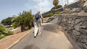 Back view of elder 70s man with walking disability holding knob of cane, leaning on gimp stick walking in the park, suffering from muscles problems, bones disease, recovering after trauma - Powered by Shutterstock - Get 15% off with code: PIKWIZARD15