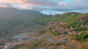Aerial view of flooded terraced fields reflecting the sky, nestled beside a village and mountains, creating a tapestry of textures, Yuanyang, China. - Powered by Shutterstock - Get 15% off with code: PIKWIZARD15
