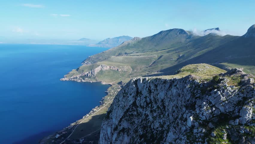 Aerial drone footage of Monte Monaco, San Vito Lo Capo, Sicily: 360° panoramic view of sea and mountains under golden Mediterranean light. Perfect for travel, nature, and adventure projects.