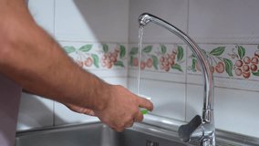 A person washes fresh vegetables in the kitchen sink, highlighting the importance of rinsing for health and hygiene. Clean water flows from the faucet, ensuring ingredient freshness for cooking - Powered by Shutterstock - Get 15% off with code: PIKWIZARD15