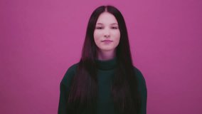 Beautiful cheerful brunette young girl wearing green pink sweater posing isolated on pink wall. Dancing shaking head with flowing hair. Teenage woman shakes her straight black long hair, slow motion. - Powered by Shutterstock - Get 15% off with code: PIKWIZARD15