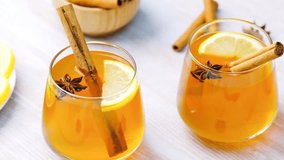 Warm apple cider with cinnamon sticks, star anise, and lemon slices in glasses - Powered by Shutterstock - Get 15% off with code: PIKWIZARD15