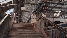 A stylish woman in white walks down the stairs at Colombo Fort train station in Sri Lanka. This travel footage captures the historic architecture and vibrant atmosphere, perfect for tourism and - Powered by Shutterstock - Get 15% off with code: PIKWIZARD15
