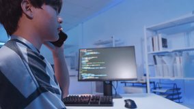 Young male Asian IT freelancer programmer and tech engineer remotely works with computer and mobile phone, software codes for application development, and web network system information data in room. - Powered by Shutterstock - Get 15% off with code: PIKWIZARD15