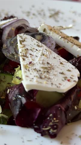 Eating traditional Greek salad. Fresh vegetable salad with feta cheese.