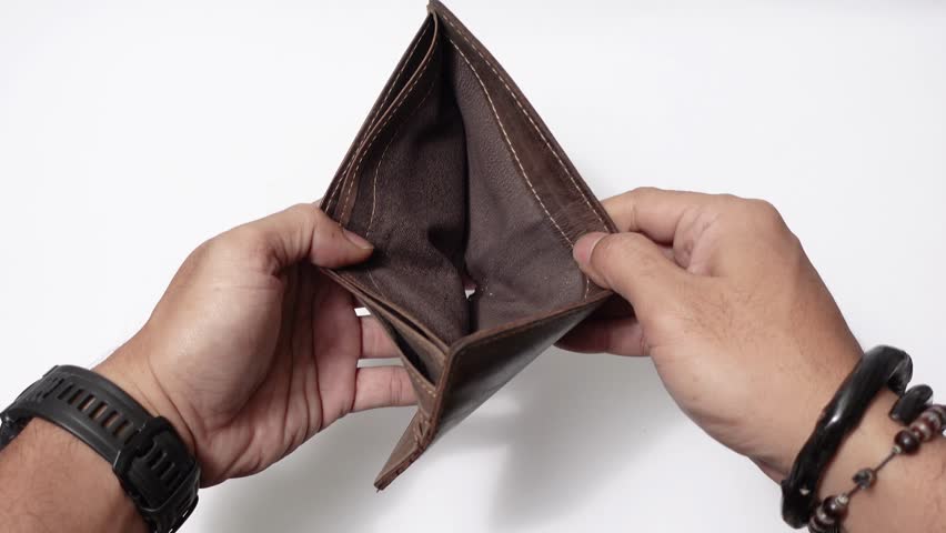 Empty wallet without any cash left. A worn brown leather wallet is opened by two hands, revealing a empty.