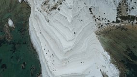 Aerial drone footage of Scala dei Turchi, Sicily: white marl cliffs descending into turquoise sea, coastal waves and dramatic Mediterranean light. Ideal for travel, nature, and heritage projects. - Powered by Shutterstock - Get 15% off with code: PIKWIZARD15
