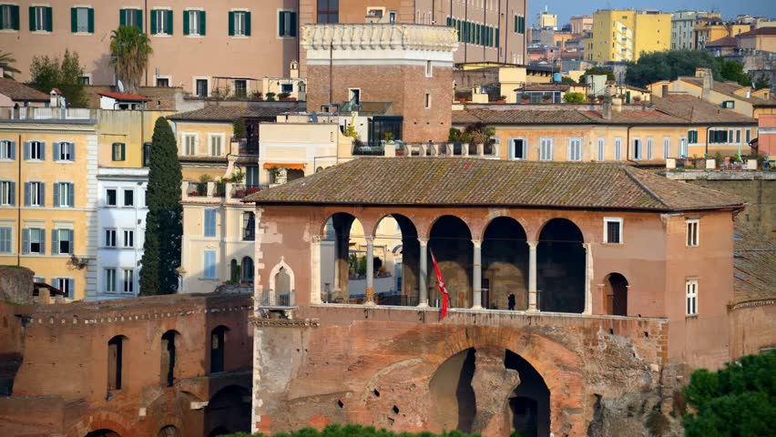 Top-down view of Rome, Italy, showing city rooftops, architecture, and urban layout under bright daylight.