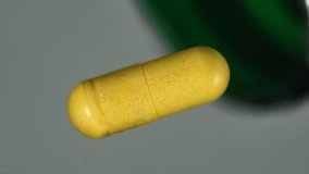 Macro shot of yellow medicine capsules spilling in slow motion. High-quality pharmaceutical footage representing healthcare, supplements, and medical research visuals. - Powered by Shutterstock - Get 15% off with code: PIKWIZARD15