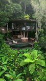 Aerial view of a handcrafted luxury treehouse nestled on a green hillside in Ubud, Bali. Surrounded by jungle and featuring an infinity pool, this tropical retreat offers the perfect serene escape. - Powered by Shutterstock - Get 15% off with code: PIKWIZARD15