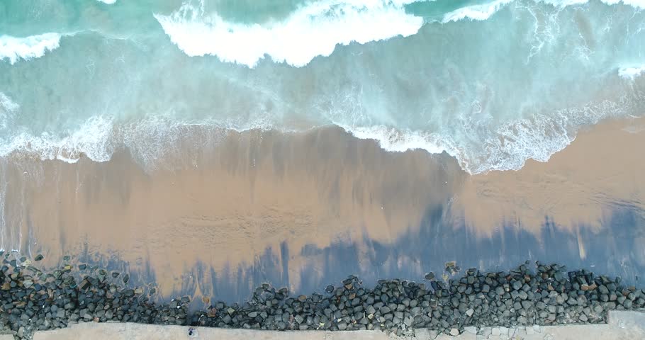 Top-down drone shot of turquoise ocean waves crashing on golden sand at Kerala beach, India. Perfect tropical texture background for travel, nature, or cinematic visuals.