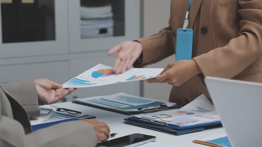 team of multiethnic architects working on construction plans in meeting room engineers discussing on project in office mature businessman and woman standing around table working on blueprint no logos