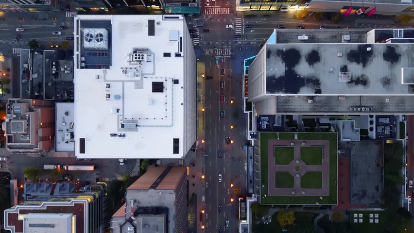 Stunning top drone view in warm colours of building rooftops, modern downtown skyscrapers, busy traffic, crossroads in evening Toronto, Ontario, Canada.
