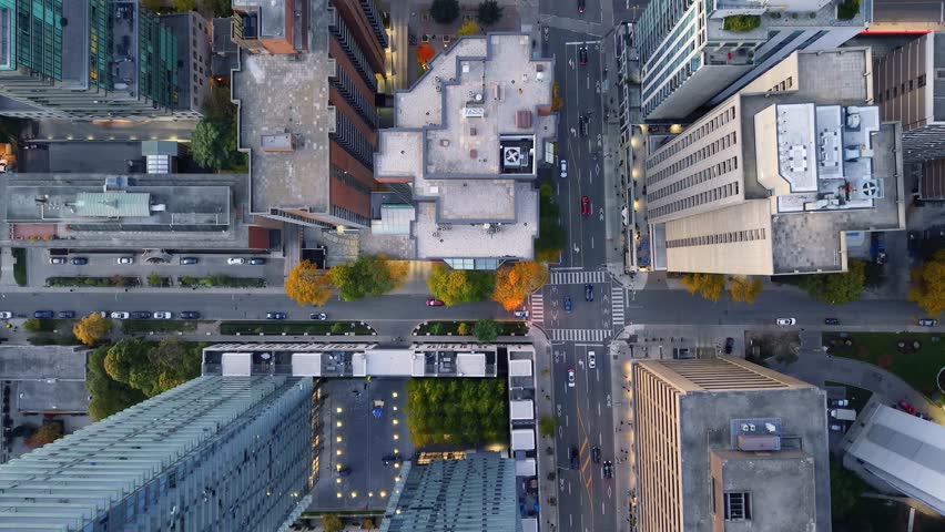 Stunning top drone view in warm colours of building rooftops, modern downtown skyscrapers, busy traffic, crossroads in evening Toronto, Ontario, Canada.