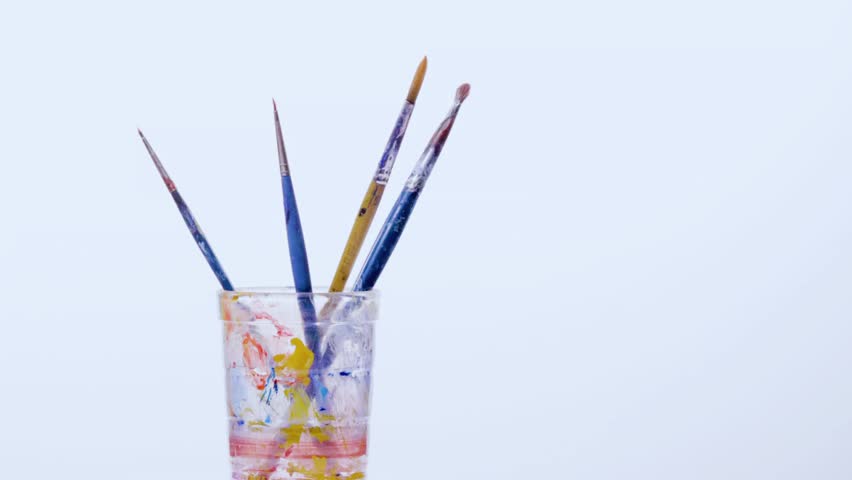 Artist's paint brushes standing in a glass, colored with vibrant paints. A creative still life showcasing tools of the trade in colorful chaos. - Powered by Shutterstock - Get 15% off with code: PIKWIZARD15