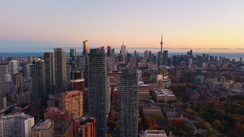 Spectacular panoramic evening drone view of modern Downtown skyscrapers, CN Tower and Lake Ontario in Toronto, Ontario, Canada.
