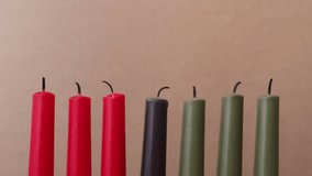 African American Kwanzaa holiday concept with traditional lit candles. Seven candles red, black and green - Powered by Shutterstock - Get 15% off with code: PIKWIZARD15