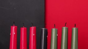 African American Kwanzaa holiday concept with traditional lit candles. Seven candles red, black and green - Powered by Shutterstock - Get 15% off with code: PIKWIZARD15
