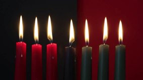 African American Kwanzaa holiday concept with traditional lit candles. Seven candles red, black and green - Powered by Shutterstock - Get 15% off with code: PIKWIZARD15
