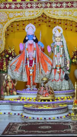 Colorful sculpture showing Lord Rama and Sita seated together in palace, symbolizing love and righteousness.