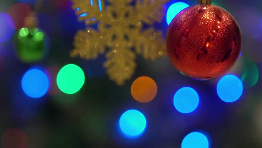 A close-up view captures a lustrous red Christmas bauble and a sparkling gold snowflake ornament suspended against a backdrop of soft, colorful bokeh lights, creating a magical and festive holiday amb - Powered by Shutterstock - Get 15% off with code: PIKWIZARD15