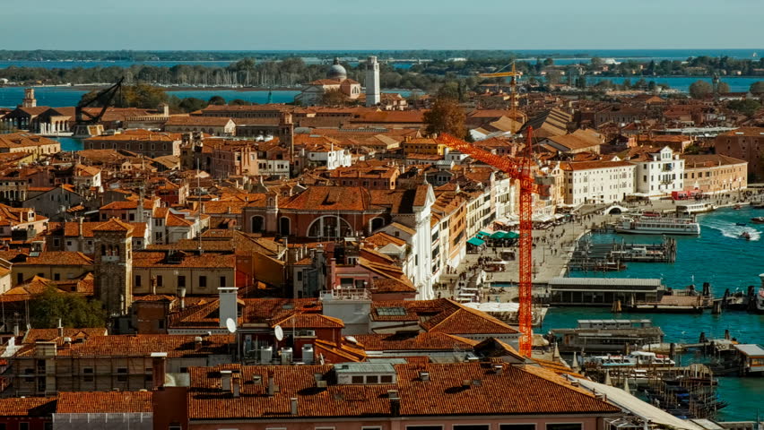 Aerial view of Venice, Veneto, Italy, revealing the lagoon city with canals, islands, church domes and red tiled roofs spreading toward the horizon
