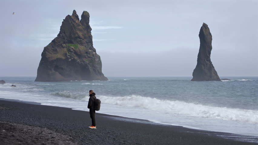 Man Standing by Ocean on Reynisfjara Beach Iceland