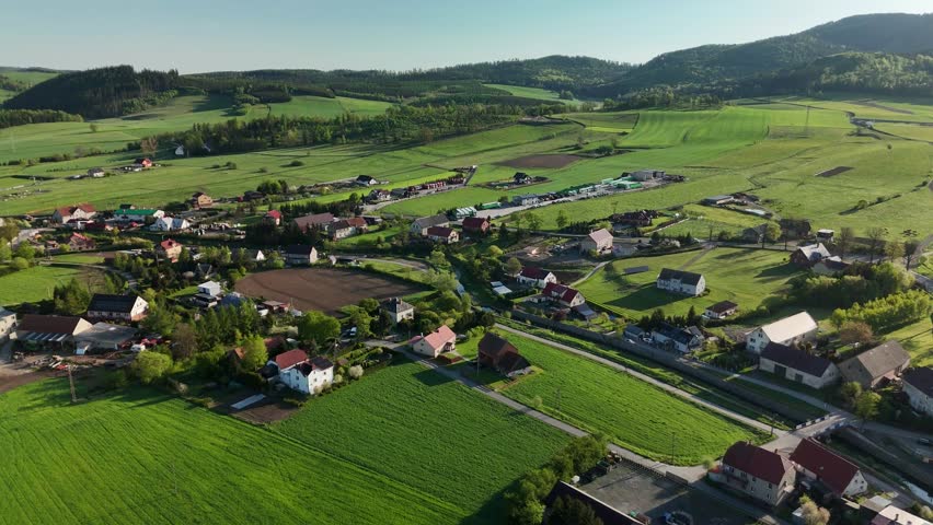 Charming Polish Village in Mountain Region with Country Road, Green Fields, and Blue Sky
