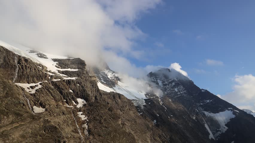 Alps mountains 4K timelapse of moving dark rain clouds. Alps in Austria video showing dramatic clouds moving over rugged mountain peaks, capturing the natural beauty and dynamic landscape of the Alps