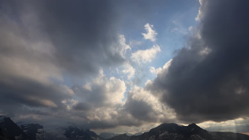 Alps mountains 4K timelapse of moving dark rain clouds. Alps in Austria video showing dramatic clouds moving over rugged mountain peaks, capturing the natural beauty and dynamic landscape of the Alps