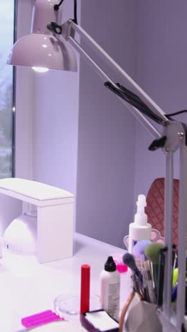 Close-up Modern Nail Salon Workplace with Manicure UV Lamp. a professional nail salon workplace setup, featuring a UV or LED drying lamp, various tools, and manicure accessories.