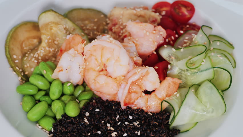 Healthy shrimp bowl with tomatoes, quinoa, edamame, and zucchini