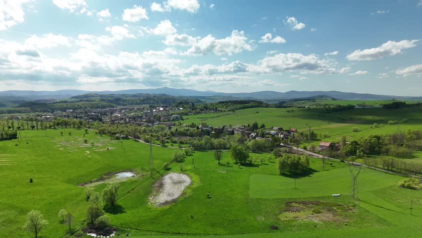 Charming Polish Village in Mountain Region with Country Road, Green Fields, and Blue Sky
