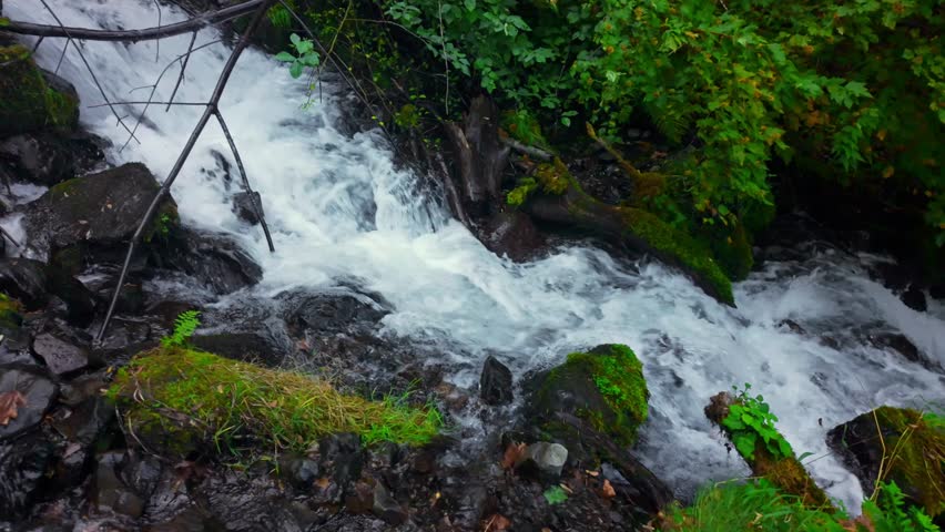 A stunning view of Wahkeena Falls, a multi-tiered, mossy waterfall cascading over basalt cliffs, located within the lush and picturesque Columbia River Gorge National Scenic Area in Oregon