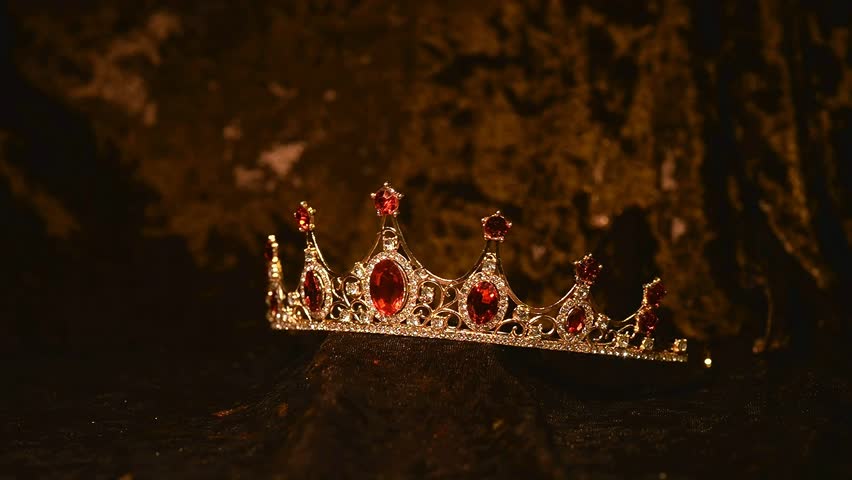 Crown with red gemstones on velvet background