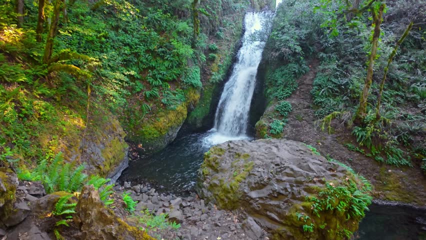 A beautiful view of Bridal Veil Falls, a distinctive two-tiered waterfall with a wispy, veil-like appearance, located near the historic Bridal Veil Falls State Scenic Viewpoint in the Columbia River G