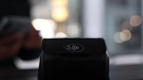Close up view of a person using a smartphone to make a contactless payment on a modern pos terminal, illustrating the convenience and speed of wireless transaction technology in a retail setting - Powered by Shutterstock - Get 15% off with code: PIKWIZARD15