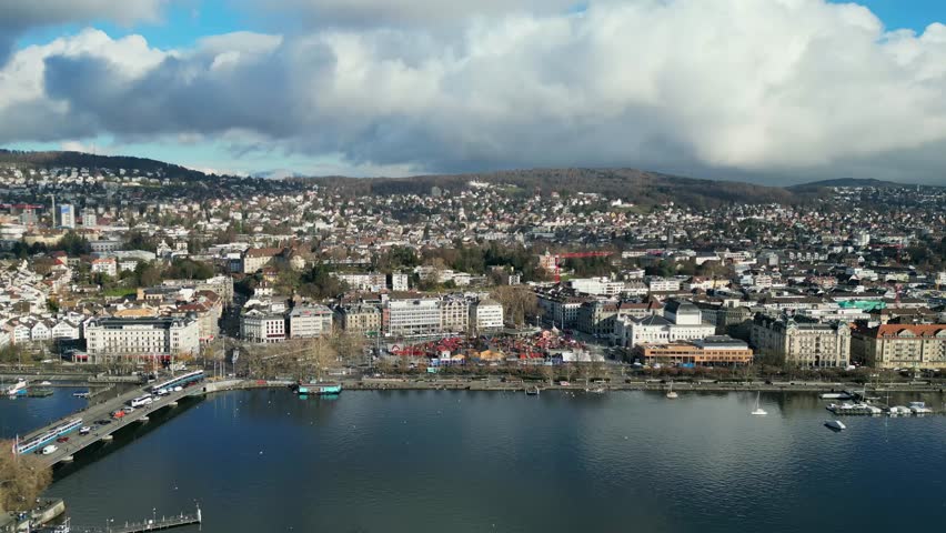 Beautiful panoramic aerial drone view of Zurich, Switzerland, with Lake Zurich in the foreground on a bright sunny day — showcasing the city skyline, waterfront, and surrounding Alps.